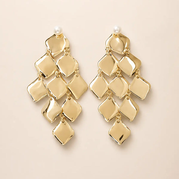 Goldfarbene Statement-Ohrstecker mit Perlenakzent und kaskadenförmig angeordneten, glänzenden Metallplättchen. Elegantes, geometrisches Design mit luxuriöser Ausstrahlung – ideal für festliche Anlässe, Hochzeiten und besondere Events.